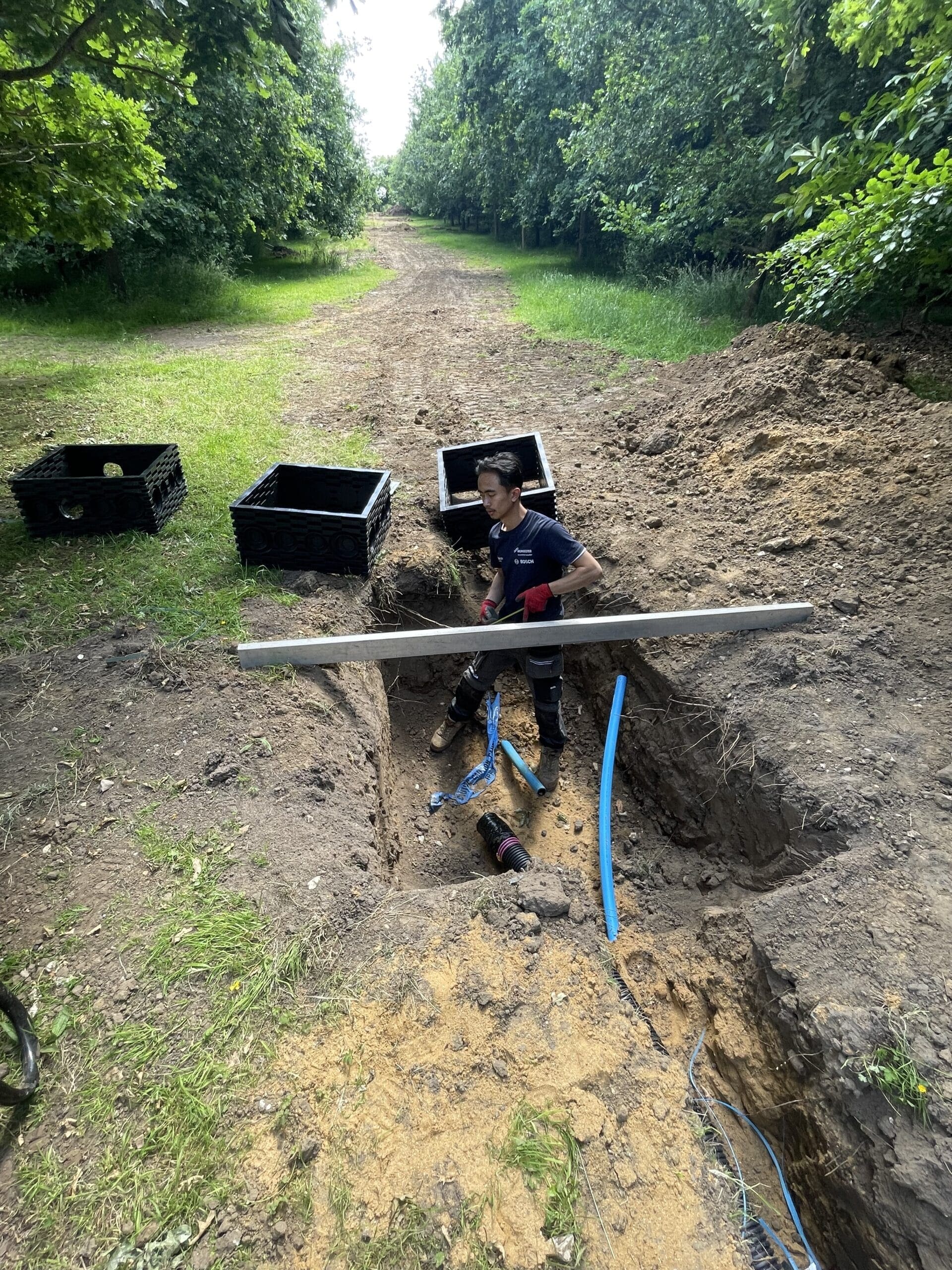 Mains water pipe installation in Norfolk with blue water pipework and trench excavation