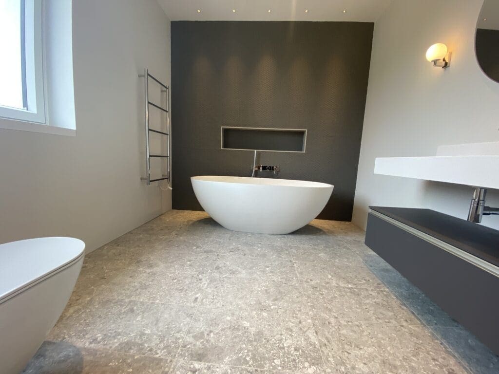 Plumber assessing shower pressure and bathroom layout in a Hunstanton bungalow