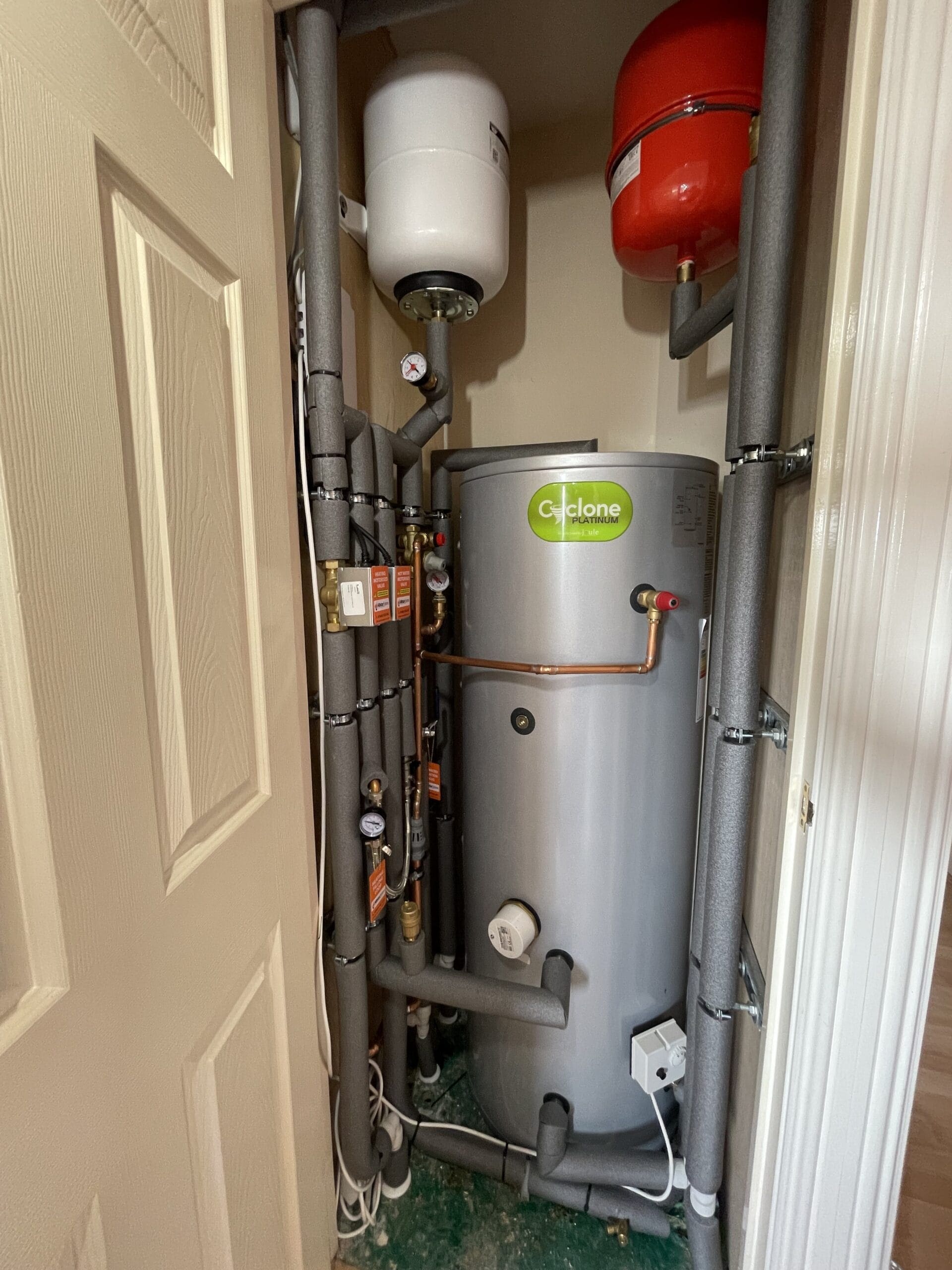Engineer checking a hot water cylinder in a Costessey home