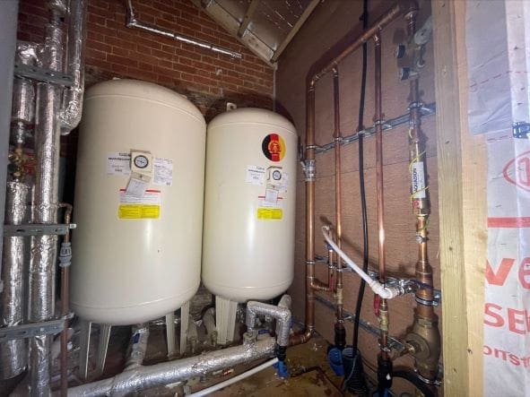 Twin water accumulator tanks installed with copper pipework to improve mains water pressure and flow in Norfolk
