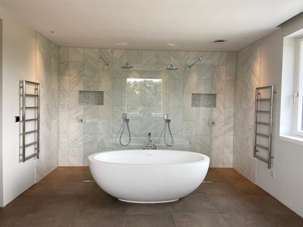 Plumber assessing bathroom layout and hot water requirements in a Wymondham home