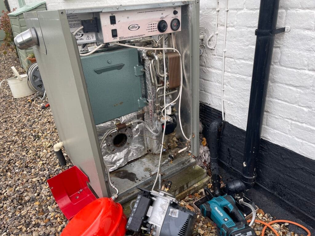 Heating engineer carrying out a professional oil boiler service in a Norfolk home