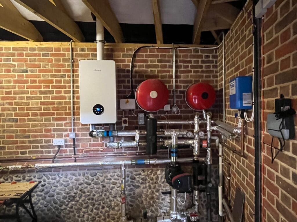 Commercial LPG boiler installation with insulated pipework, expansion vessels, pumps and heating controls in a plant room