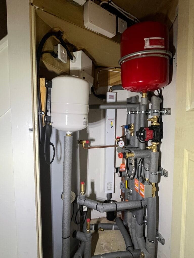 Heating engineer assessing controls and radiator performance in a Wymondham home